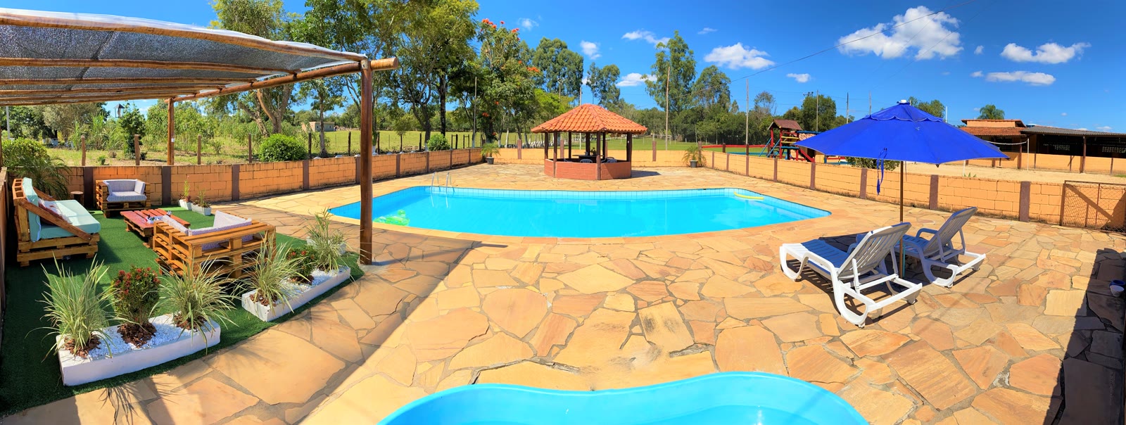 Piscina vista de cima com pergolado e guarda-sol